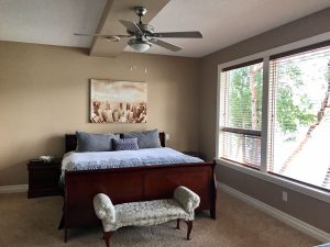 Massive windows with large bed and view of lake from master bedroom in this Lakeview Rental Home