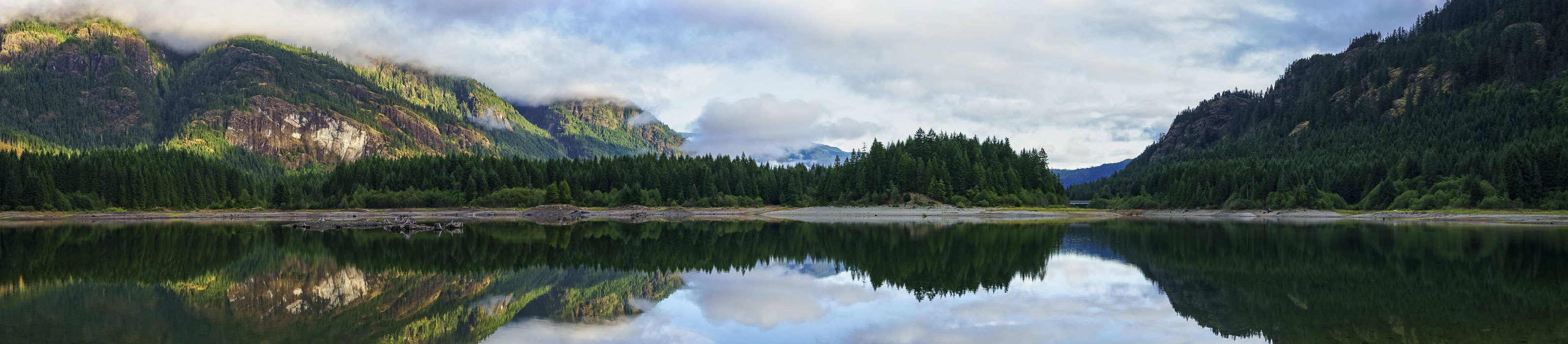 Reflective water with green mountains