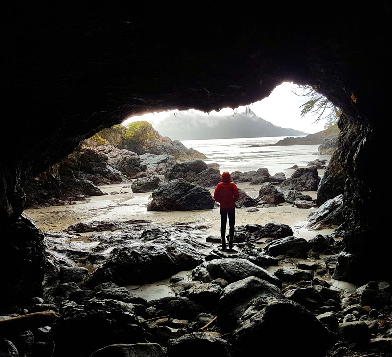 Woman standing in large cave on Vancouver North Island